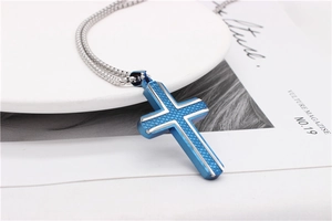 Detail view of silver and blue cross pendant with lattice texture on beaded chain