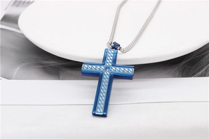 Detail of blue cross pendant with silver grain engraving and small crystal stone