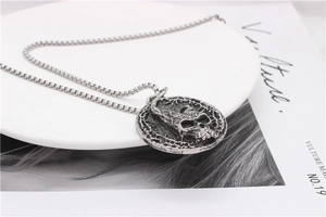 Detail of gothic silver skull pendant with oxidized vintage texture on box chain necklace