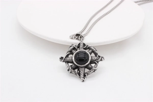 Close-up of retro cross necklace with black gemstone in a thorny star pendant
