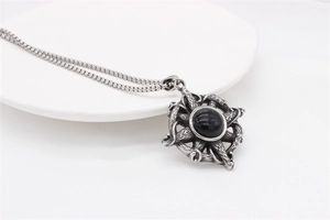 Detailed macro view of vintage silver cross pendant with a centered black gemstone
