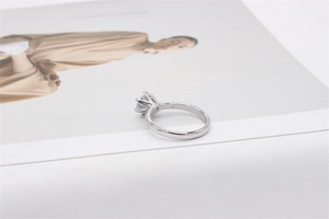 Detailaufnahme eines silbernen Rings mit Sechs-Krallen-Fassung und rundem Edelstein