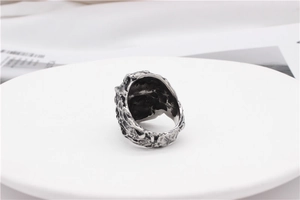 Close-up of retro punk ring with textured rock finish on white ceramic display