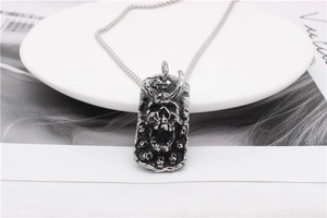 Detailed view of a vintage silver gothic skull pendant with horned demon and mini skulls