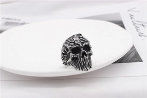 Macro shot of gothic skull ring with vintage finish on minimalist white ceramic plate