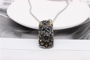 Macro shot of rectangular pendant with horned demon skull and vintage metallic texture