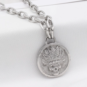 Collier punk vintage argenté avec pendentif relief crâne indien sur fond blanc texturé