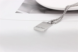 Detailaufnahme des silbernen Lucky Poker Anhängers mit rechteckigem Tag und quadratischer Boxkette