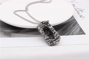 Detail shot of vintage rectangular pendant with rock texture on fine box chain necklace