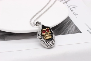 Vue détaillée du pendentif crâne gothique avec yeux en strass rouges et capuche argentée