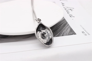 Détail d'un pendentif vintage en argent irrégulier avec une texture de cratère oxydé