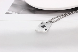 Makro-Detail des Pik-As-Anhängers aus silbernem Edelstahl mit feiner Kugelkette
