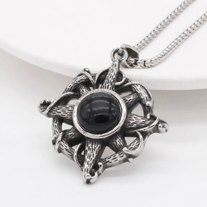 Vintage silver-tone starburst pendant with black gemstone and textured metal finish