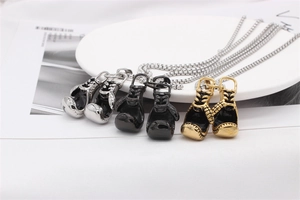 Detailed view of stainless steel boxing glove necklaces in silver, black and gold finishes