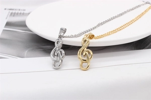 Detail of gold and silver treble clef music note pendants on stainless steel chains