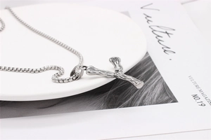 Macro shot of silver textured bamboo style pendant with box chain on artistic background