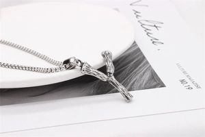 Macro detail of retro bamboo joint pendant in stainless steel on a polished box chain