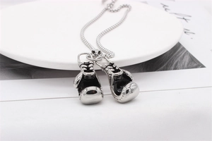 Close-up of polished silver boxing glove pendants on a vintage titanium steel necklace