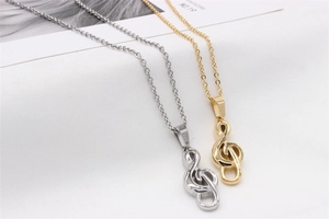 Detail of music note pendants in gold and silver finishes on delicate cable chains