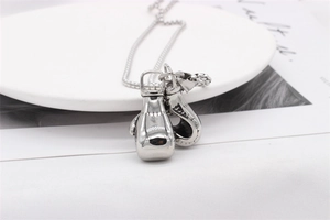 Macro shot of twin vintage steel boxing glove pendants on a round bead necklace chain