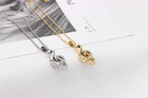 Detail of gold and silver music note necklaces on a white textured background