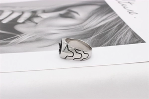 Detailed view of stainless steel men's ring featuring an embossed lion head and side grooves