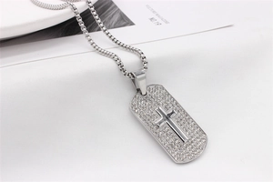 Détail du pendentif hip-hop argenté avec croix sertie de strass et chaîne box