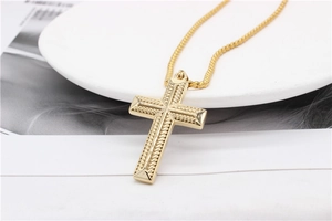 Vue détaillée du pendentif croix dorée vintage avec texture corde et chaîne gourmette