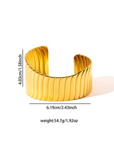 Detail view of gold wide cuff bracelet with size specs and wavy vertical texture