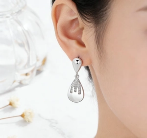 Close-up of long 925 silver drop earrings with waterdrop design and pavé zircons
