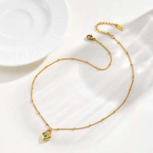 Detail of gold stainless steel necklace with turquoise heart lock charm and S.STEEL tag