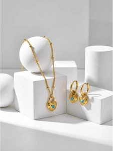 Detail of vintage heart lock necklace and earrings with turquoise on white geometry