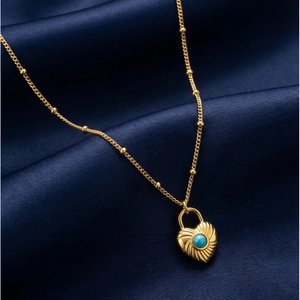 Close-up of heart lock necklace with turquoise stone on elegant blue satin