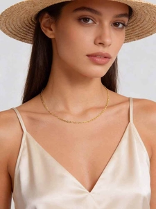 Close-up of a 2mm gold-plated O-chain necklace worn by a model with a silk dress