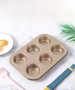 Close-up of champagne gold 6-cup muffin pan with non-stick coating on white marble
