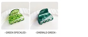 Detail view of green spotted and emerald marble texture acrylic hair claws