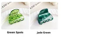 Detail view of green spotted and emerald marble texture acrylic hair claws