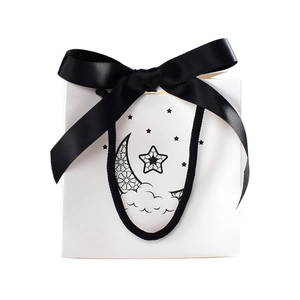 White gift bag with black satin bow and moon star mandala pattern design