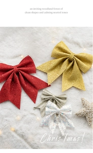 Close-up of sparkling Christmas bow ornaments with glitter finish on snow background