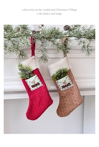 Detail of knitted Christmas stockings with XMAS pocket and pine branch decor