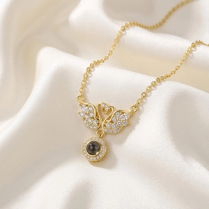 Elegant gold-tone twin swan necklace with sparkling zircon wings and projection stone pendant