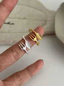 Macro shot of creative fork and spoon open ring with hammered texture on gold finish