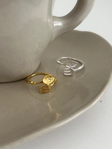 Macro detail of fork and spoon shaped open rings with hammered texture in gold and silver