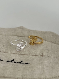 Macro shot of silver and gold cutlery rings with S925 engraving on a beige burlap bag