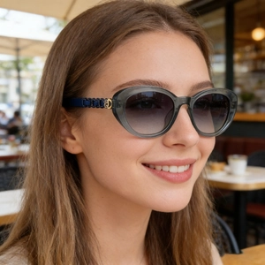 Detail of polarized sunglasses with gradient lenses and gold logo on the temple