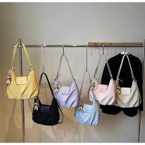 Detail showing various colors of large capacity crescent hobo bags with cute charms