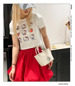 Detail of white mini leather handbag with silver heart pendant and red puff skirt