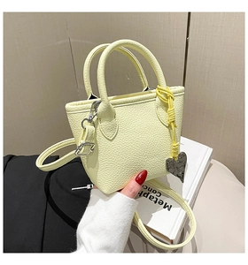 Detail of light yellow lychee grain leather mini bag with silver heart pendant