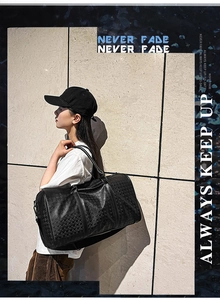 Detailed view of black PU leather travel tote with woven texture and sturdy dual handles