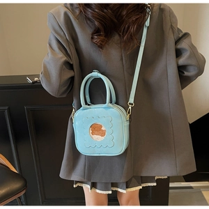 Detail of light blue crossbody bag with wave edge window and cute bear motif
